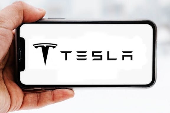 Hand-die-smartphone-hält-mit-logo-des-unternehmens-tesla