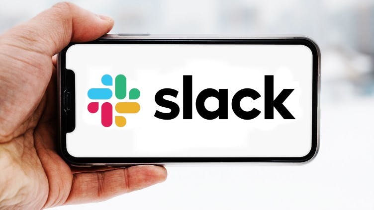 Hand, die ein Smartphone hält, auf dem das Logo des Unternehmens Slack zu sehen ist; Symbolbild für die "Aktie im Fokus"