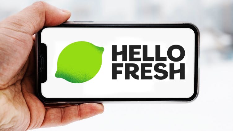 Hand-die-smartphone-hält-mit-logo-des-unternehmens-hellofresh