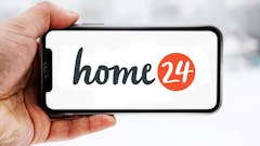Hand, die ein Smartphone hält, auf dem das Logo des Unternehmens Home24 zu sehen ist; Symbolbild für die "Aktie im Fokus"