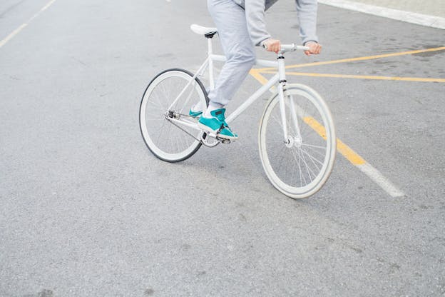 Mann auf weißem Rad mit türkisen Schuhen