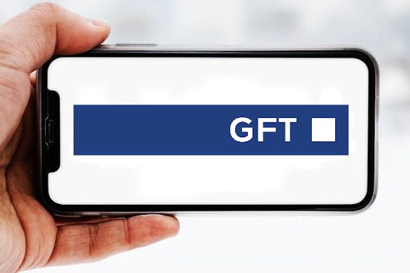 Hand, die ein Smartphone hält, auf dem das Logo des Unternehmens GFT zu sehen ist; Symbolbild für die "Aktie im Fokus"