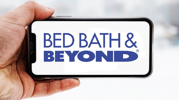 Hand, die ein Smartphone hält, auf dem das Logo des Unternehmens Bed Bath & Beyond zu sehen ist; Symbolbild für die "Aktie im Fokus"