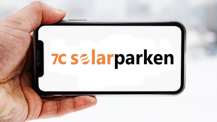 Hand, die ein Smartphone hält, auf dem das Logo des Unternehmens 7c Solarparken zu sehen ist; Symbolbild für die "Aktie im Fokus"