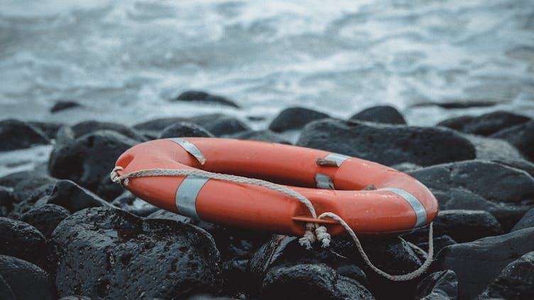 Rettungsring am
Ufer und im Hintergrund das Meer